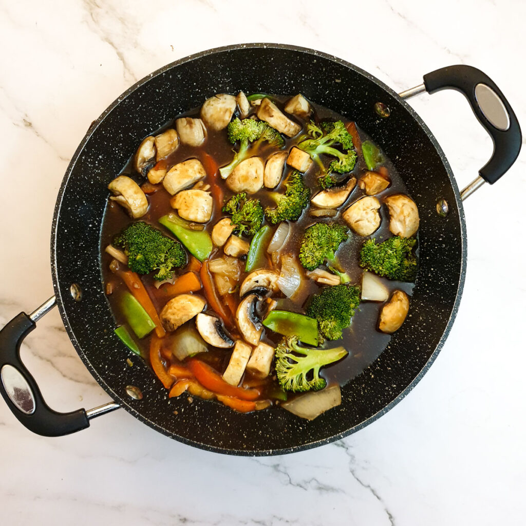 Vegetables and garlic sauce in a frying pan.