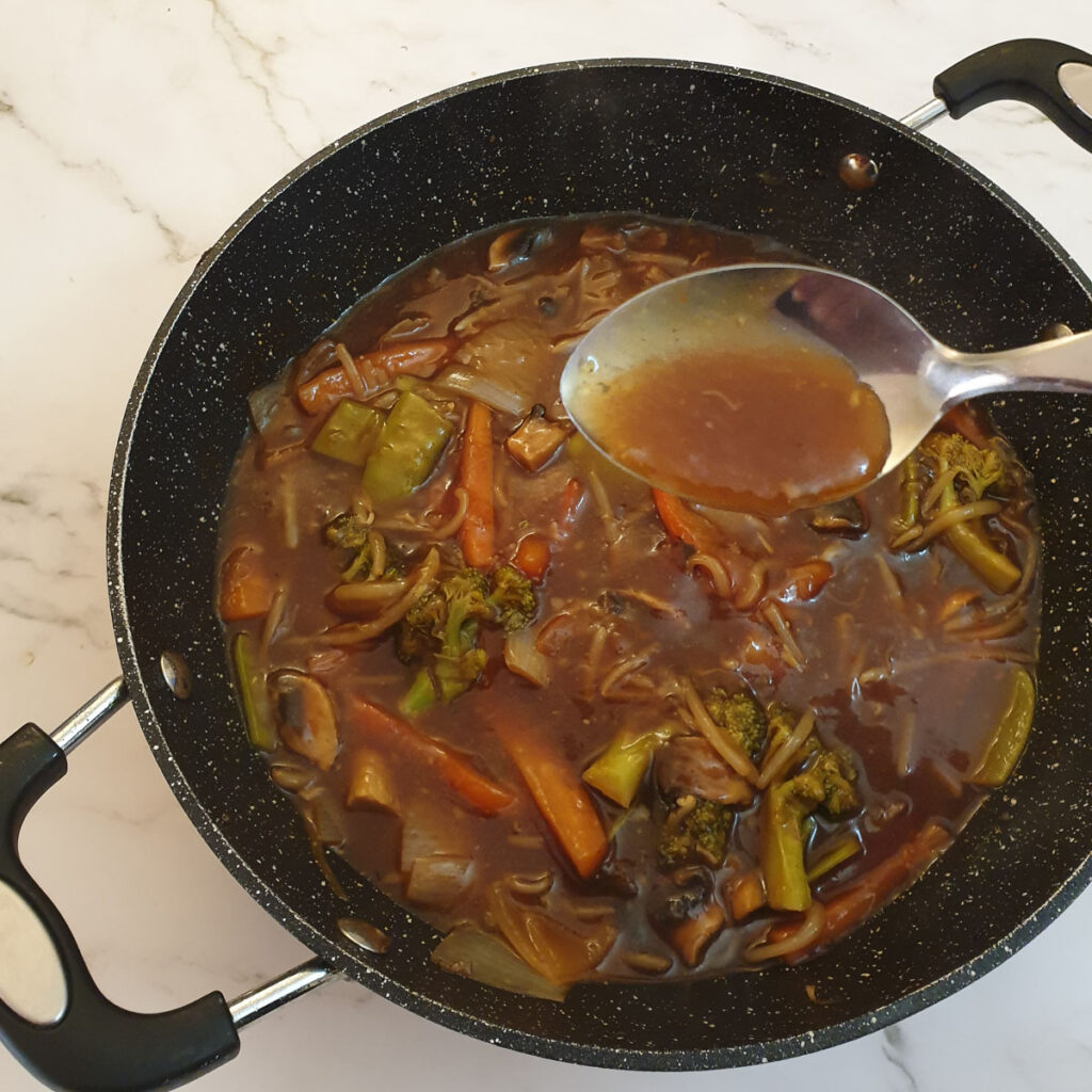 Vegetables and garlic sauce in a frying pan.