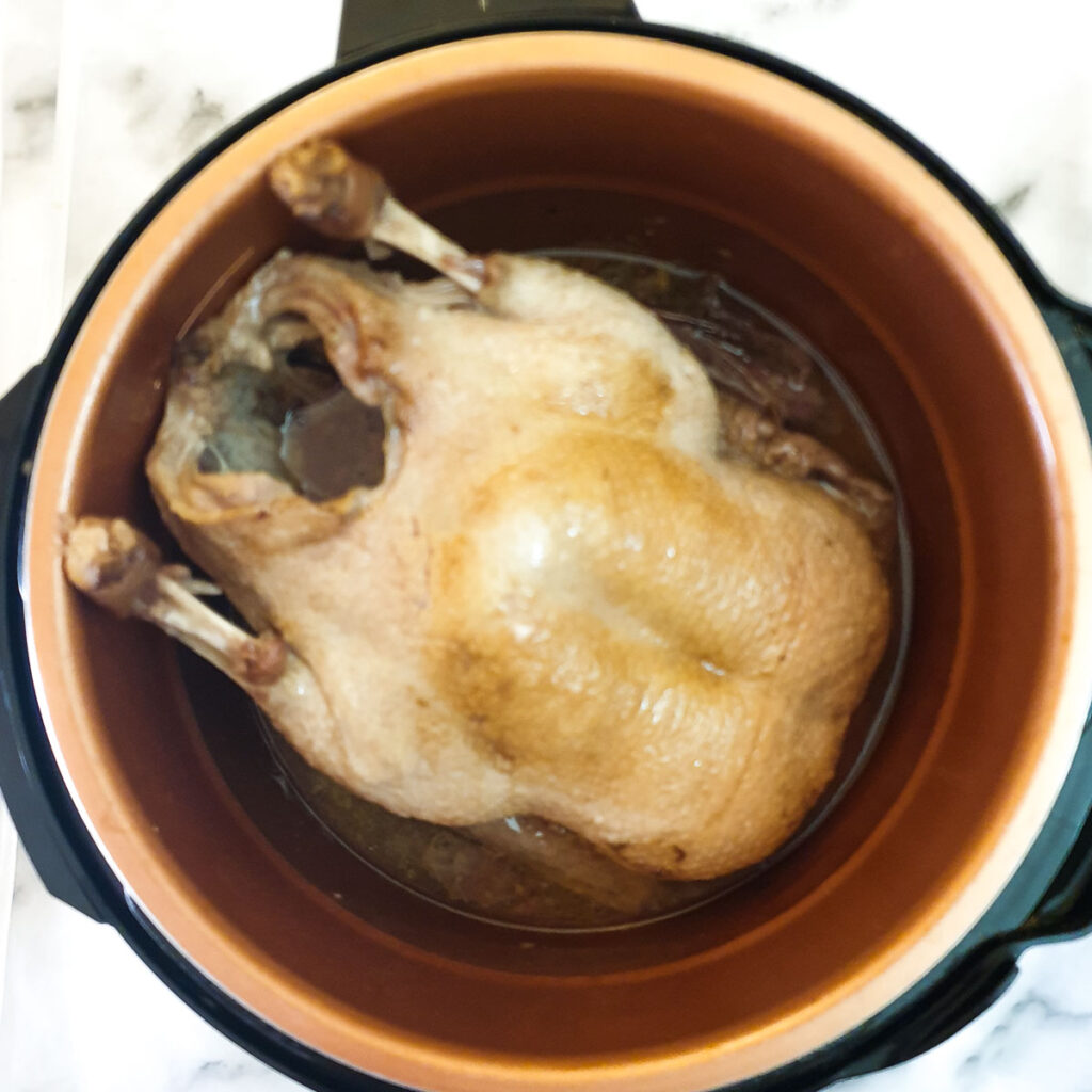 A cooked duck in a pressure cooker.