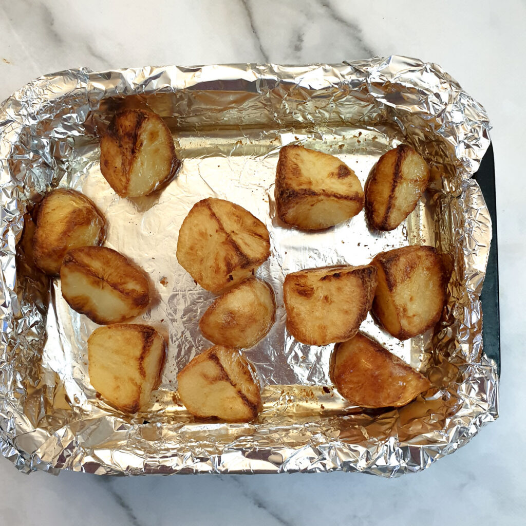 Roast potatoes in a roasting tray.