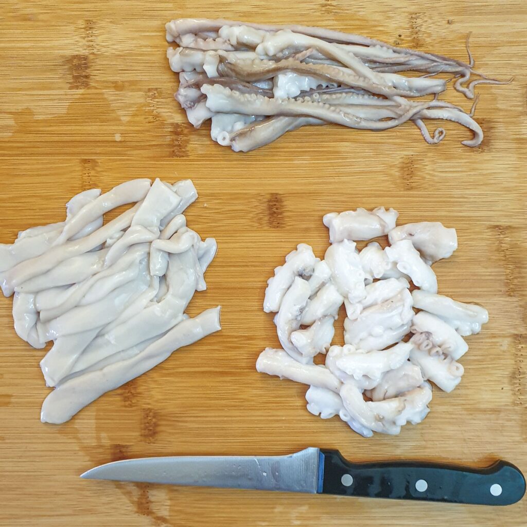 Pieces of octopus on a chopping board.