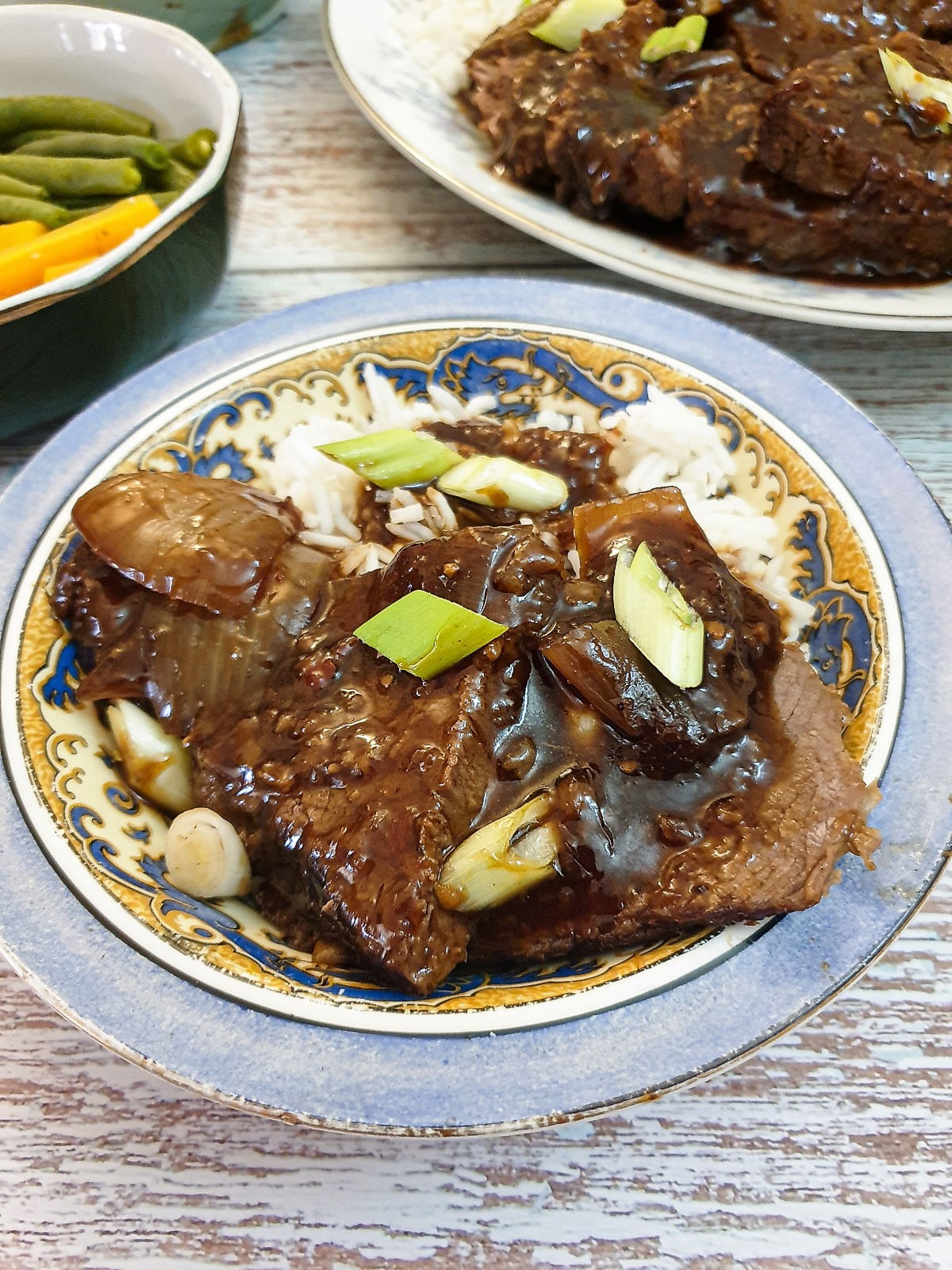 A dish of slices of mongolian roast beef with rice.