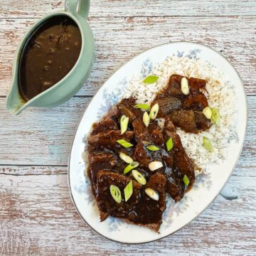 Slices of slow-cooker mongolin beef on a bed of rice.