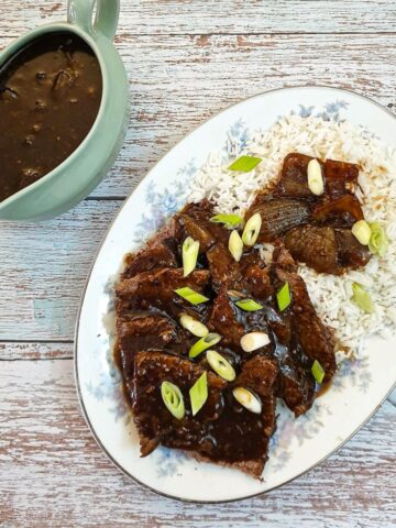 Slices of slow-cooker mongolin beef on a bed of rice.