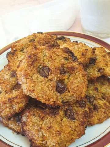 A plate of banana cornflake breakfast cakes with a glass of milk.