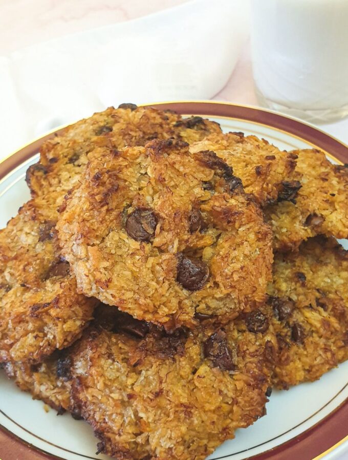 A plate of banana cornflake breakfast cakes with a glass of milk.