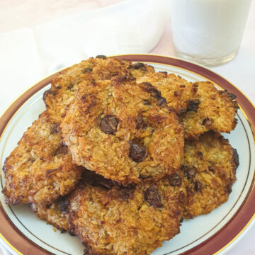 A plate of banana cornflake breakfast cakes with a glass of milk.