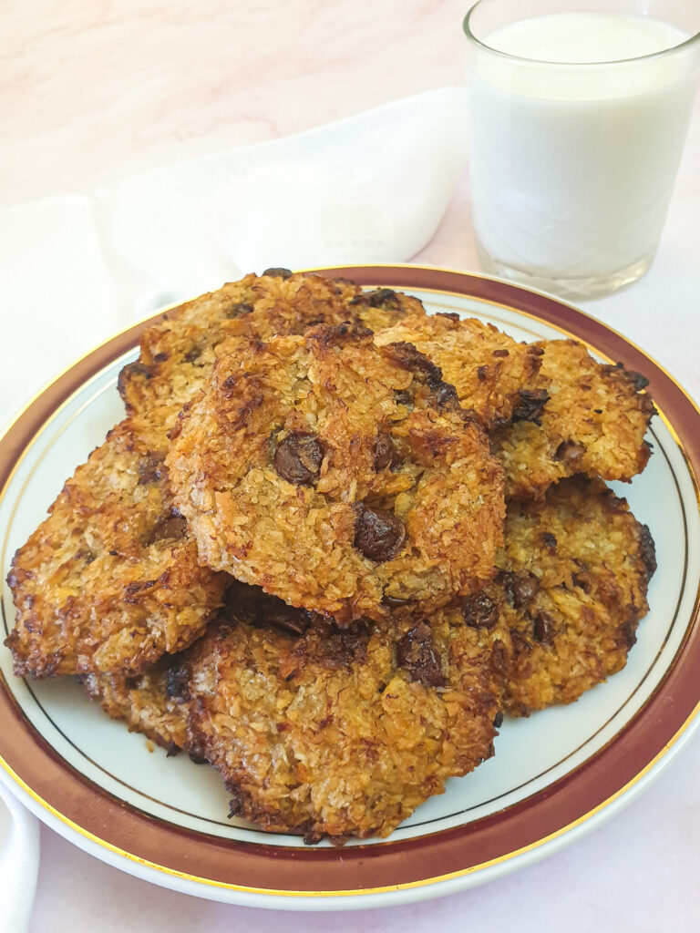 A plate of banana cornflake breakfast cakes with a glass of milk.