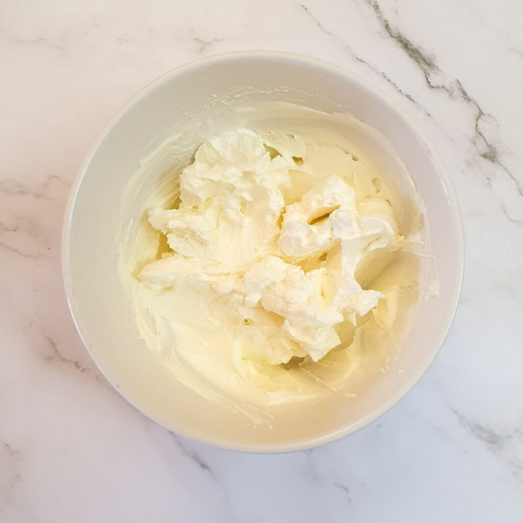 A mixing bowl containing whipped cream.
