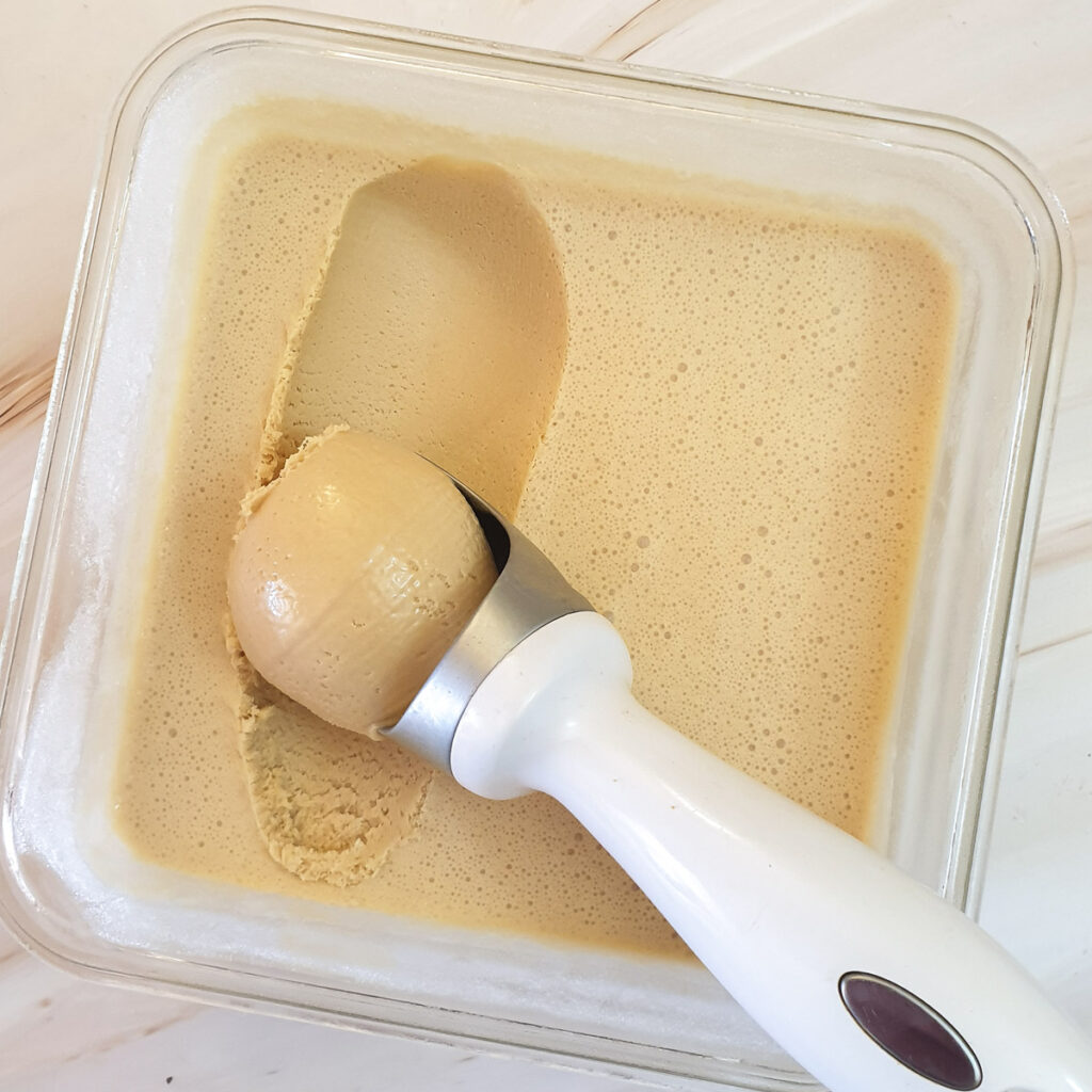 Ice cream being scooped from a container.