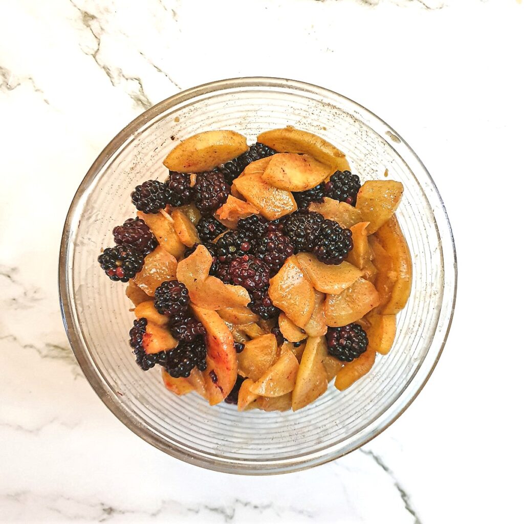 Apples and blackberries in a mixing bowl.