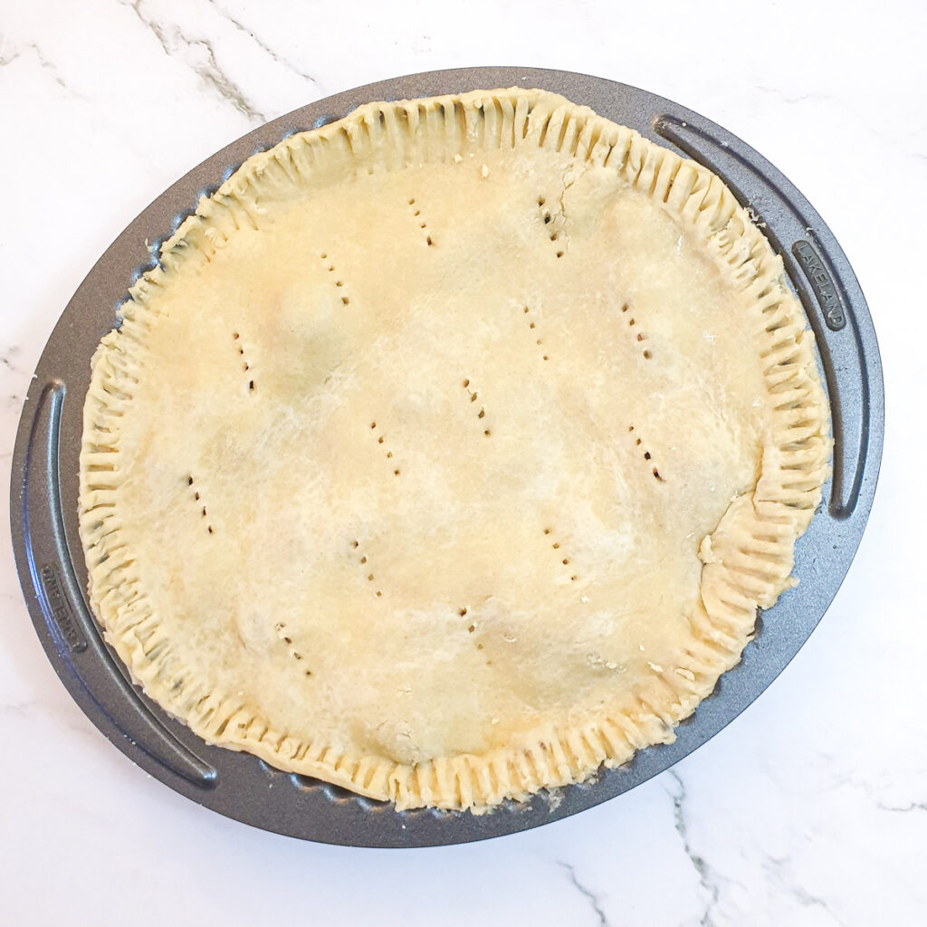 An unbaked pie in a baking dish.