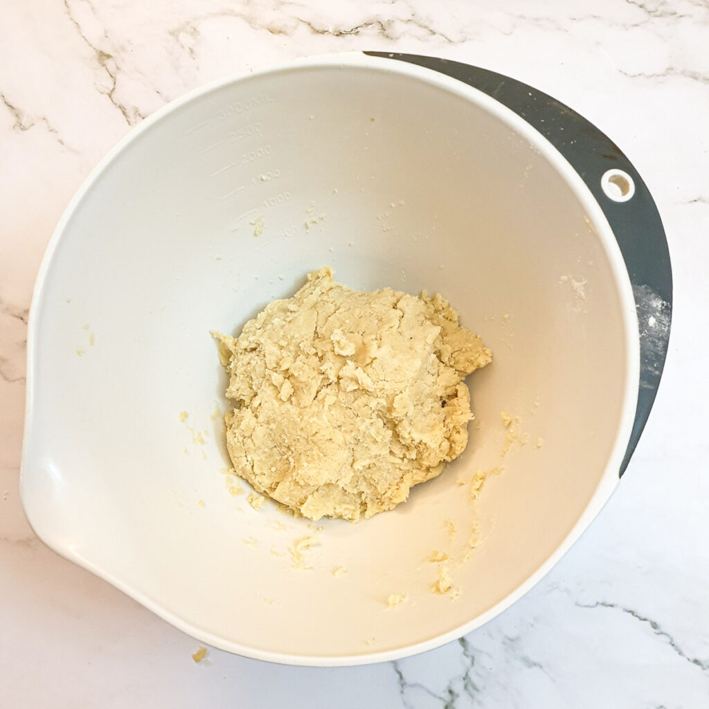 A ball of pastry in a mixing bowl.