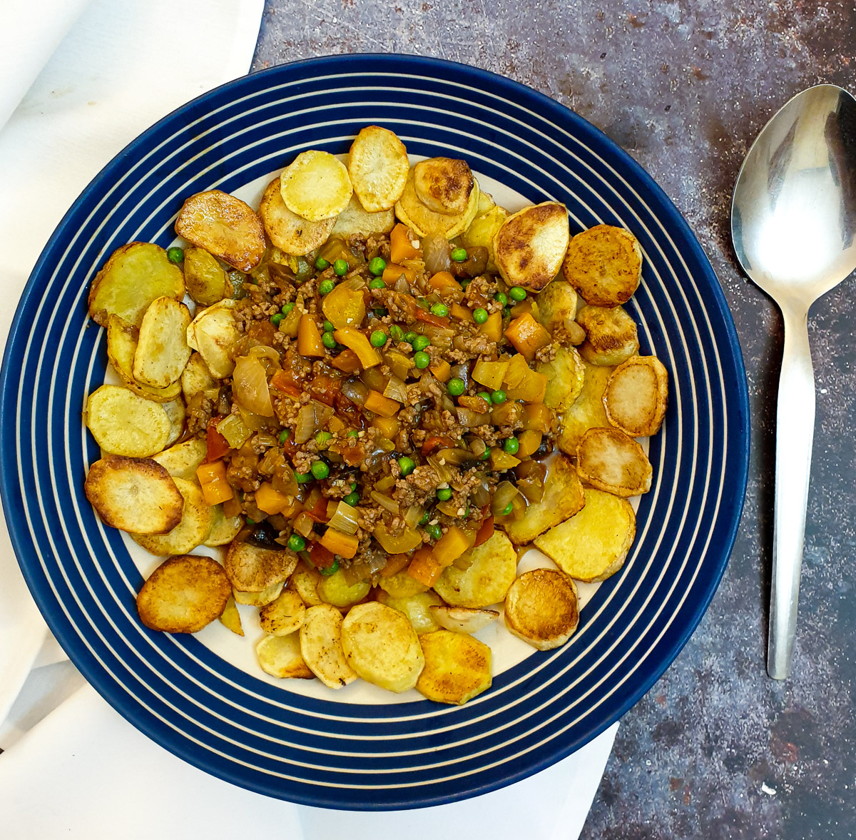 Crispy fried sliced potatoes surrounding a pile of savoury minced beef and vegetables.
