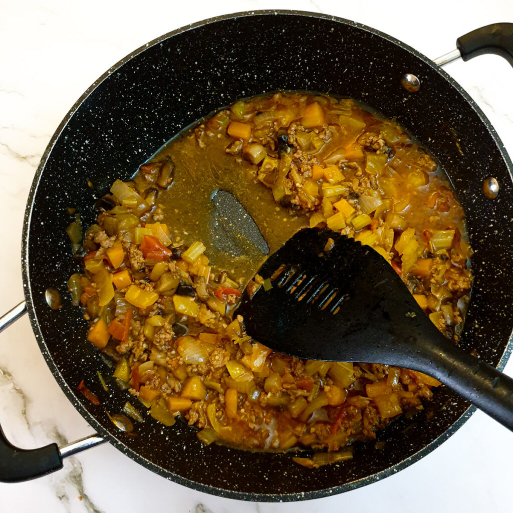 The cooked meat and vegetables, showing the consistency of the stock.