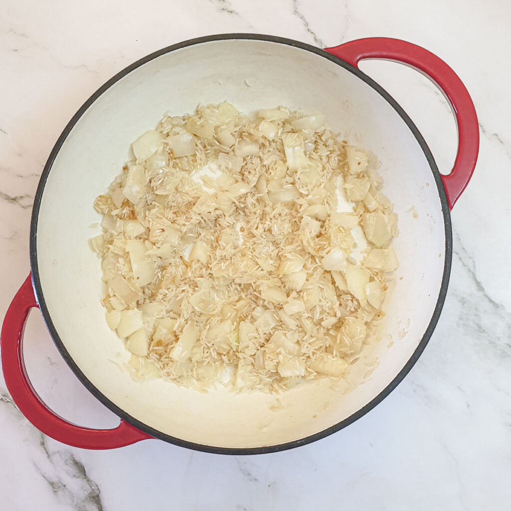 Rice and fried onions in a pan.