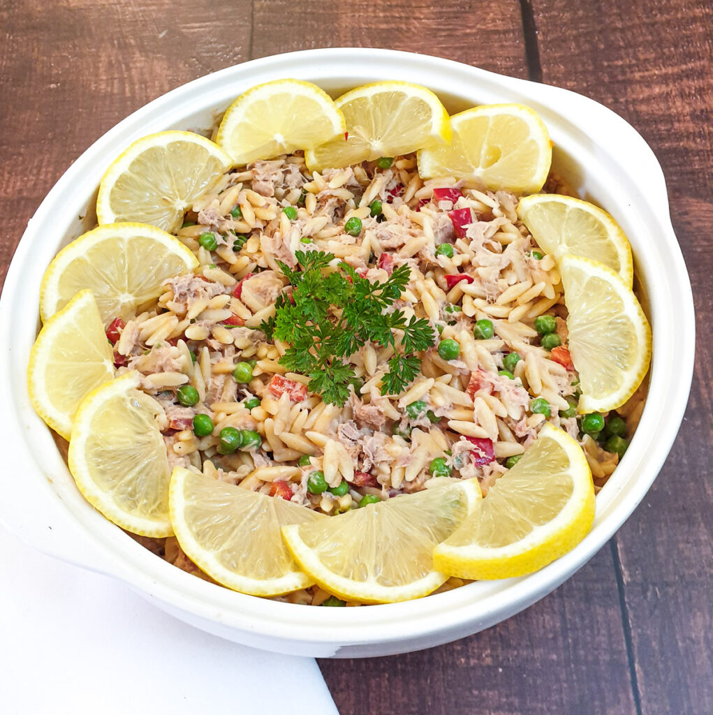 The finished dish of tuna noodle salad garnished with lemons.