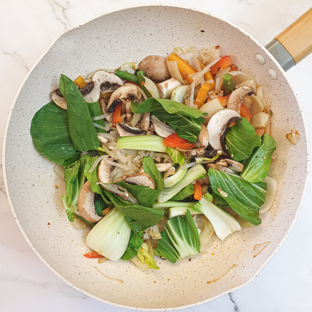 Pakchoi, mushrooms and beansprouts added to the frying pan.