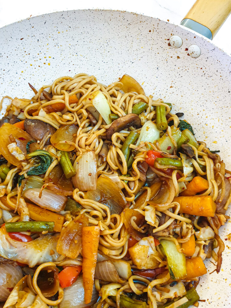 The finished dish of vegetable lo mein in a wok.