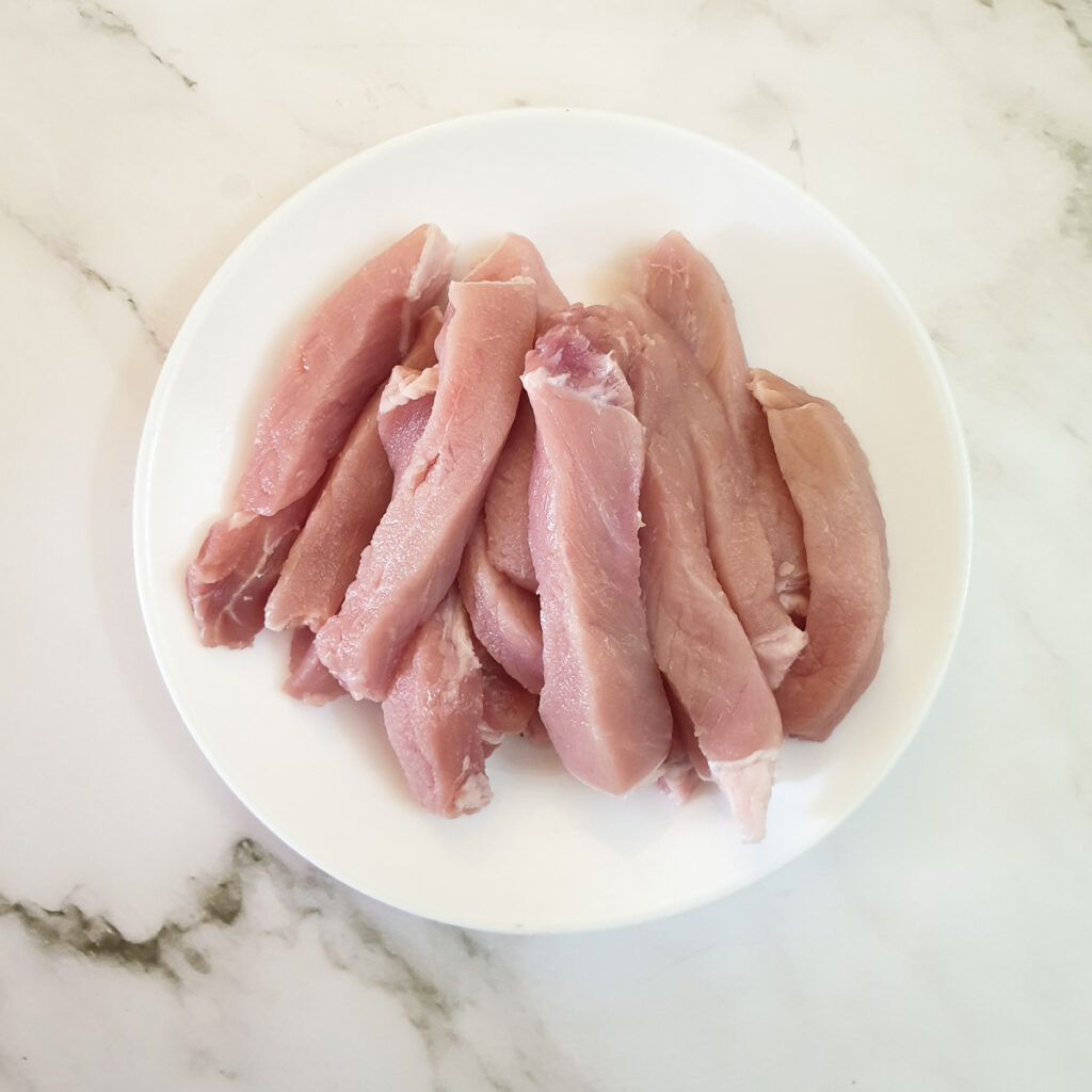 Pork loin steaks cut into finger-sized strips.