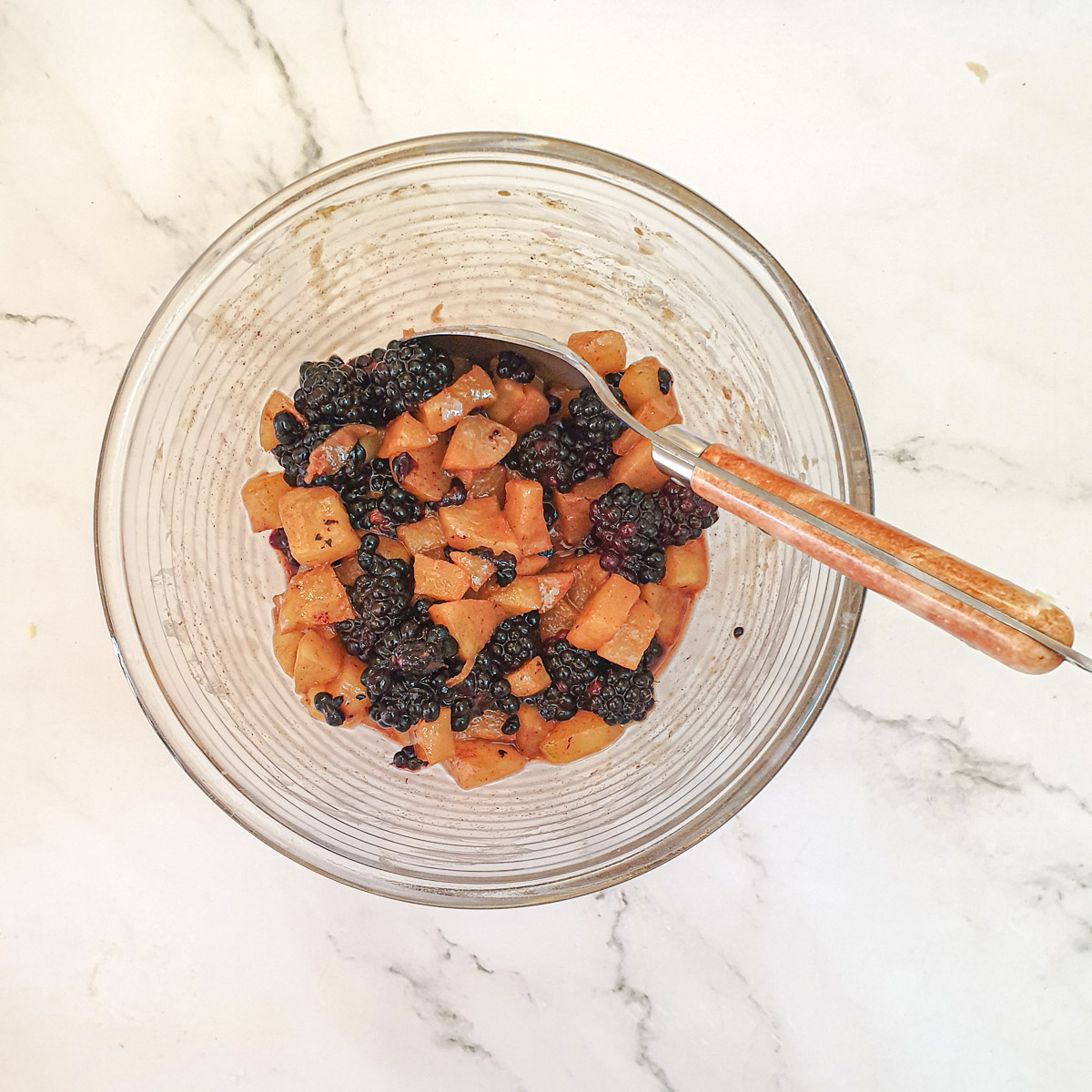 Apples and blackberries in a mixing bowl.