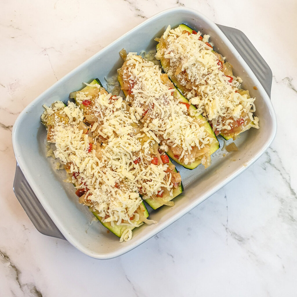 4 cabbage stuffed courgettes topped with cheese and breadcrumbs.