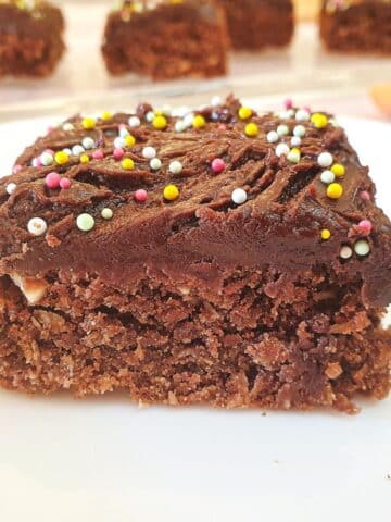 Close up of chocolate weetbix crumble cake with more slices out of focus in the background.