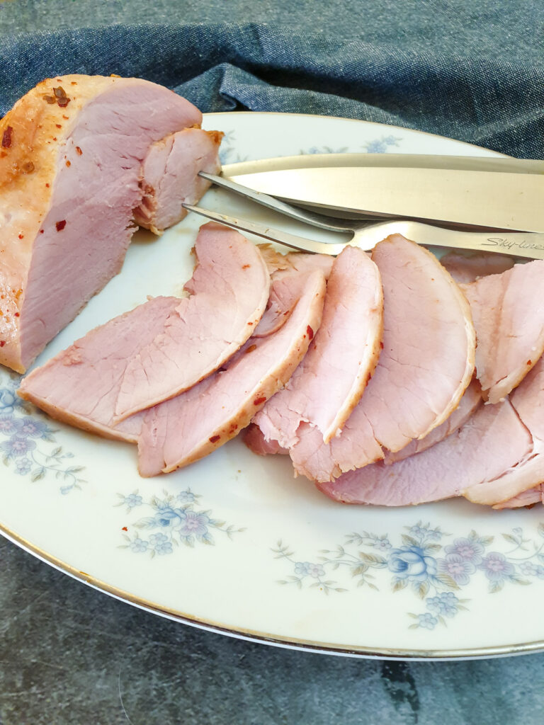 Close up of slices of oven-baked gammon on a plate.