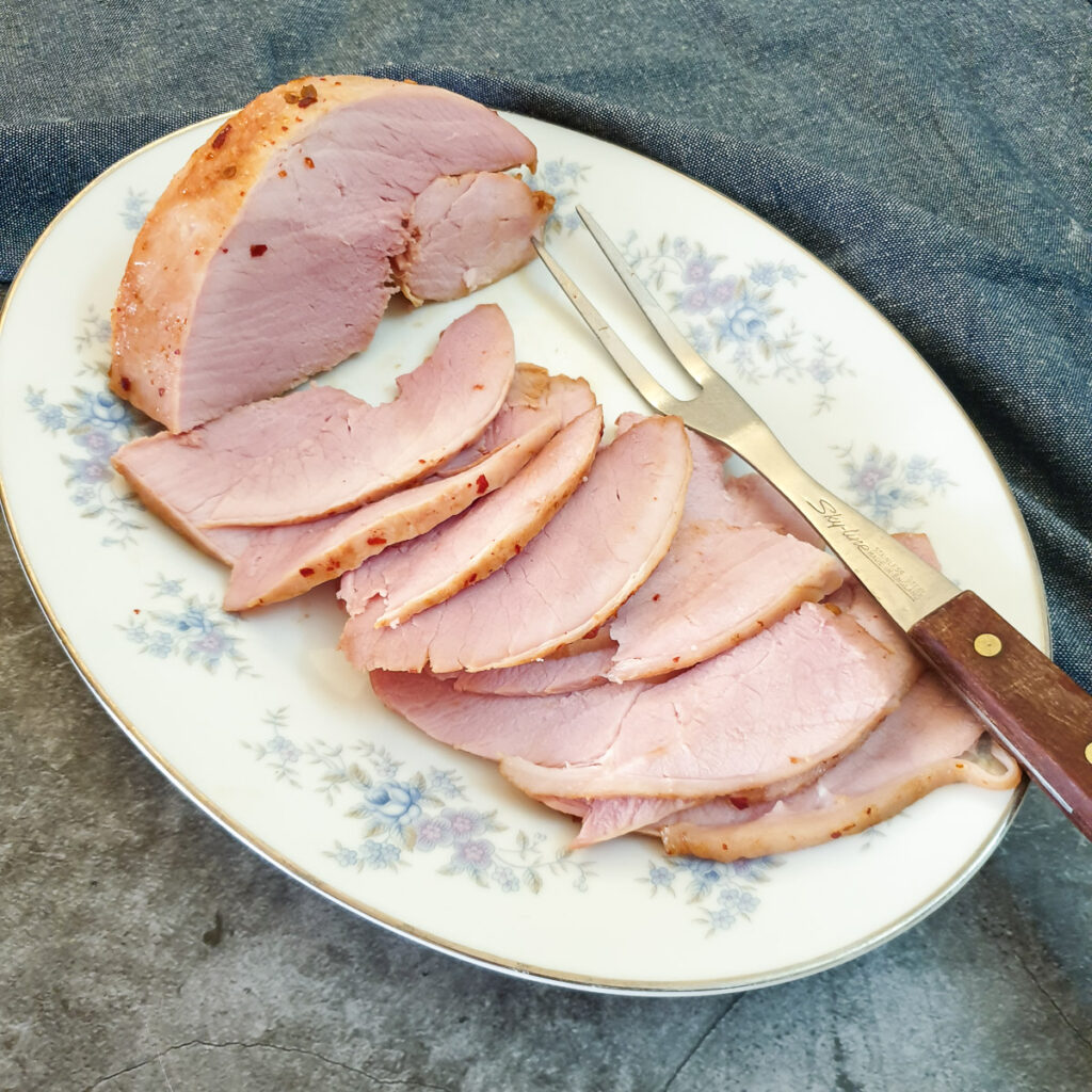 Slices of oven-baked gammon on a serving dish.