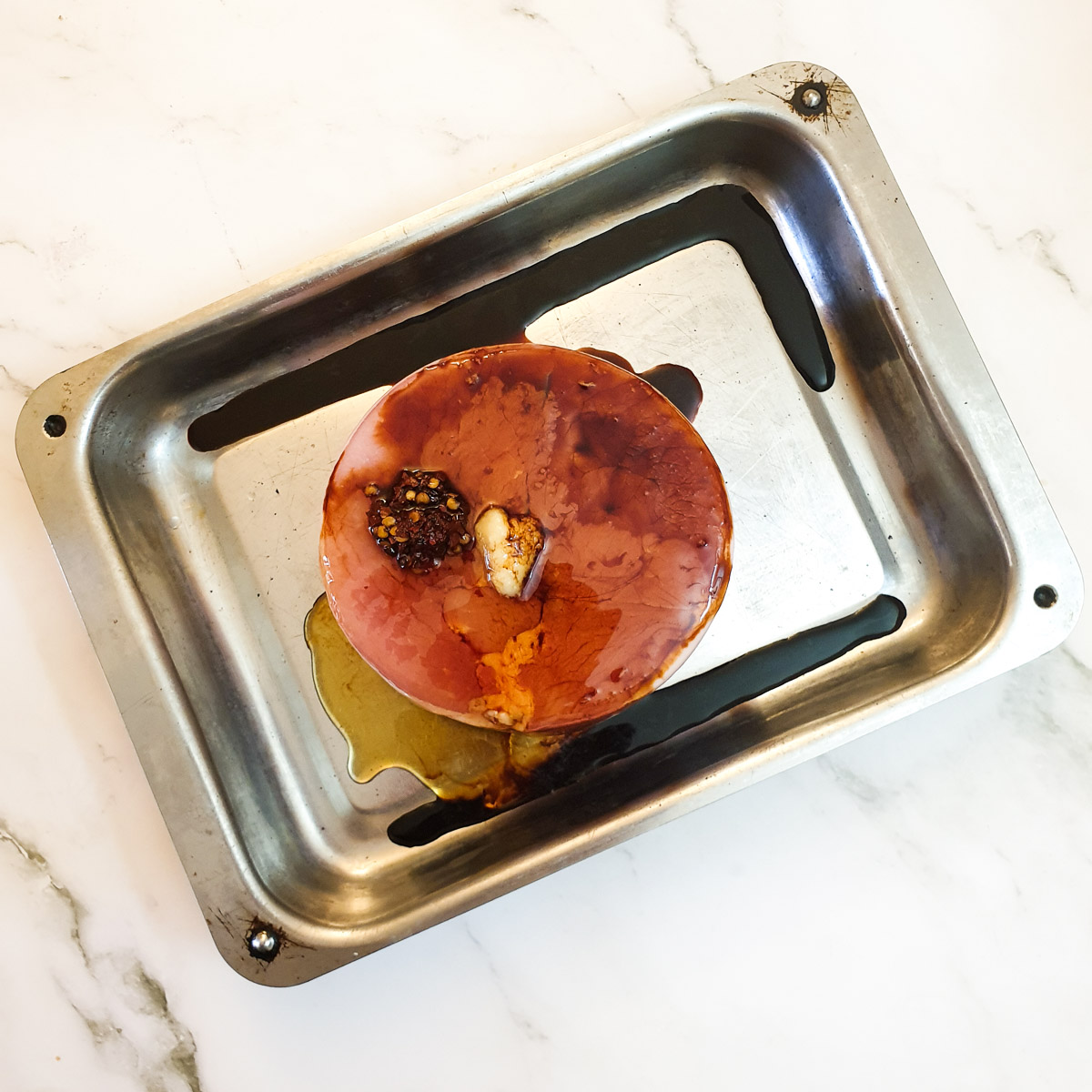 Gammon being prepared in a roasting pan.