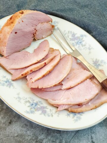 Slices of oven-baked gammon on a serving dish.