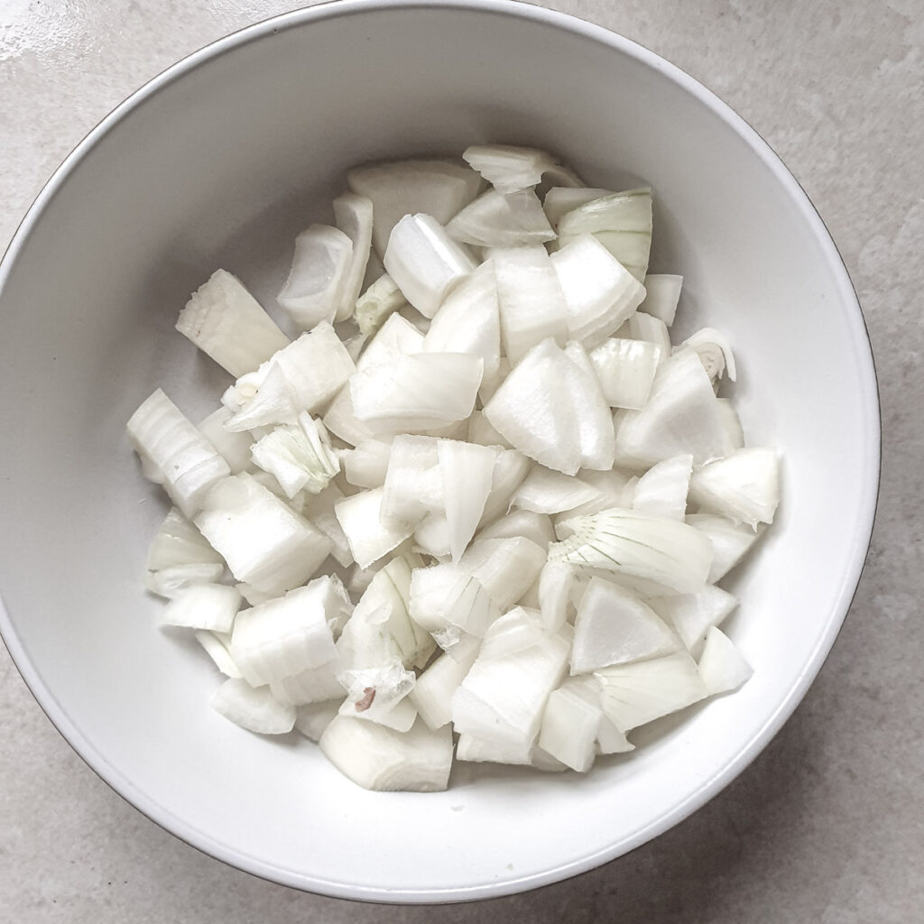 Finely chopped onions in a white dish.