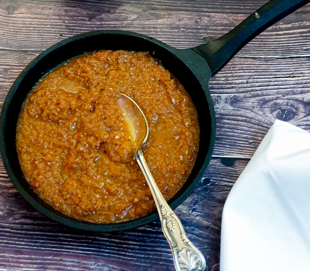 Marinara sauce in a frying pan with a spoon.