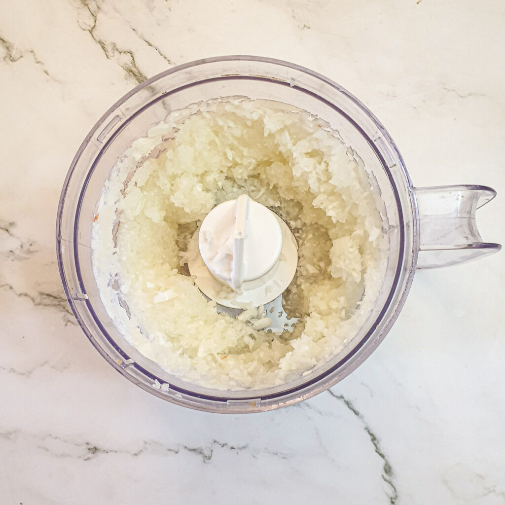 Chopped onions in a food processor.