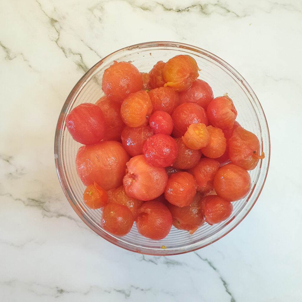 Peeled tomatoes in a glass bowl.