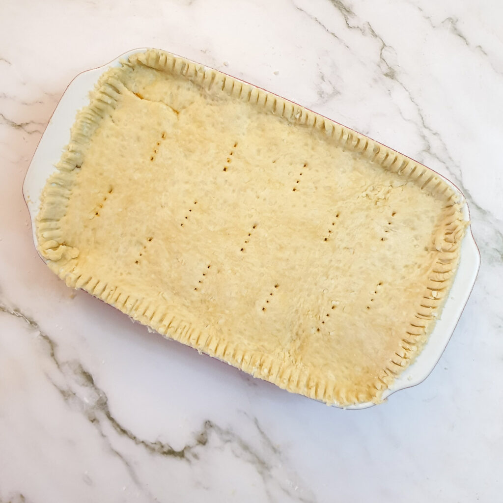 Meat and potato pie covered in suet pastry, ready for the oven.