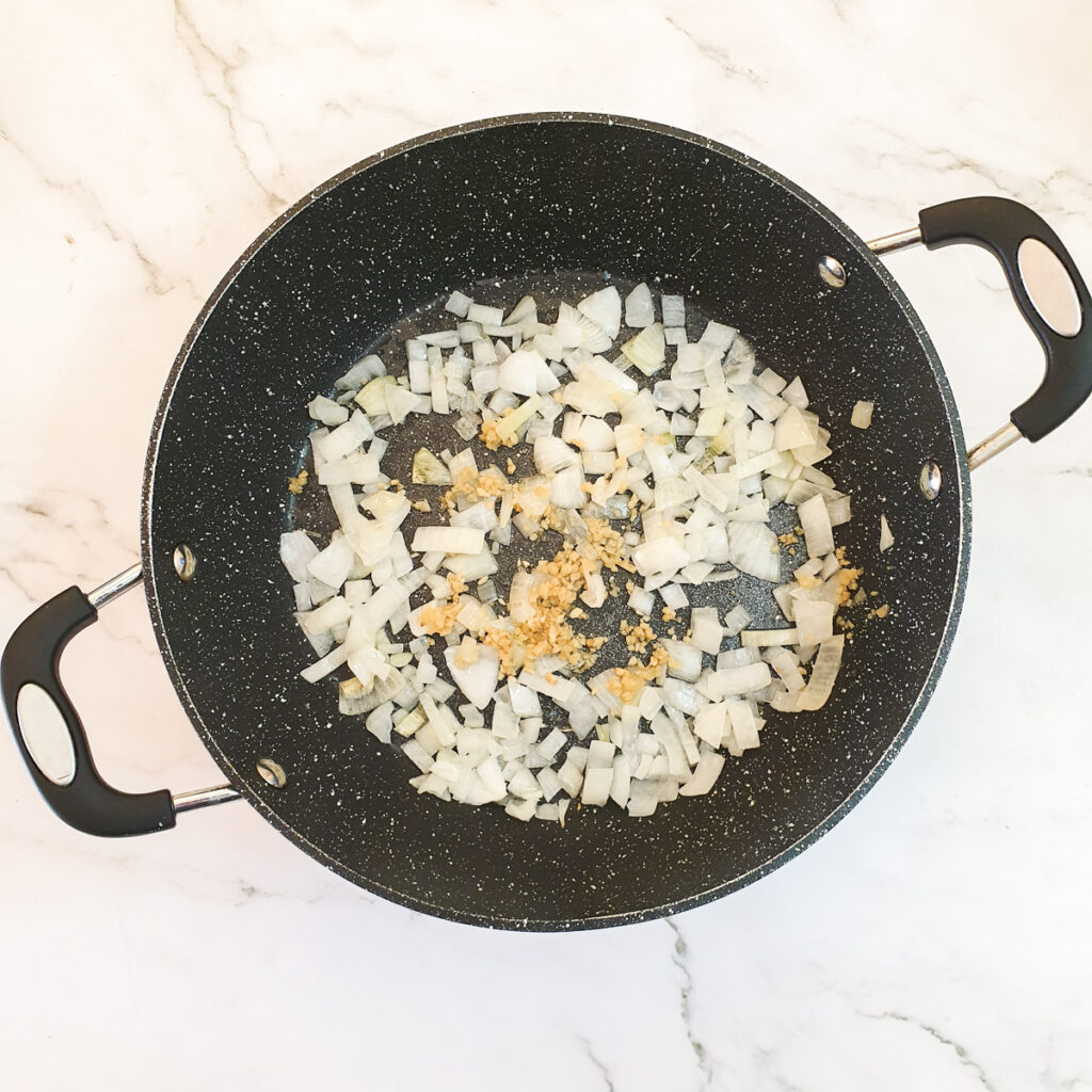 Chopped and onions and garlic in a frying pan.