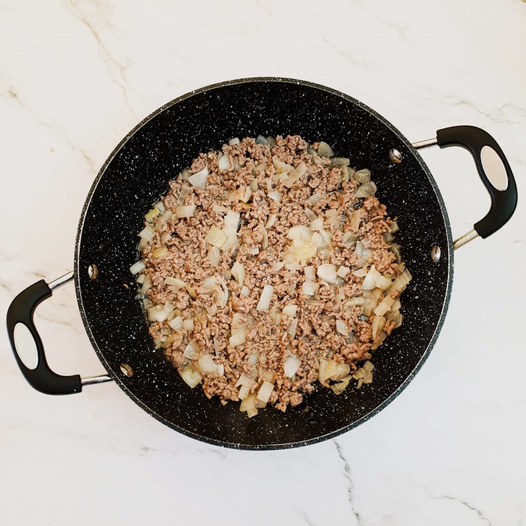 Beef mince being browned with onions and garlic.