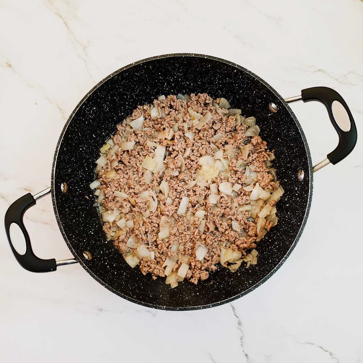Beef mince being browned with onions and garlic.