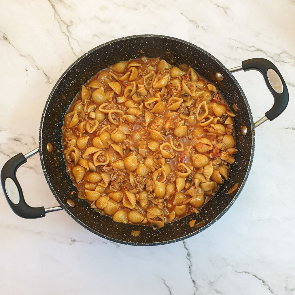 Cheesy mince pasta in a pan once the pasta has been cooked.