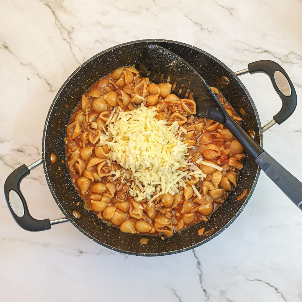 Cheese being added to the mince pasta.