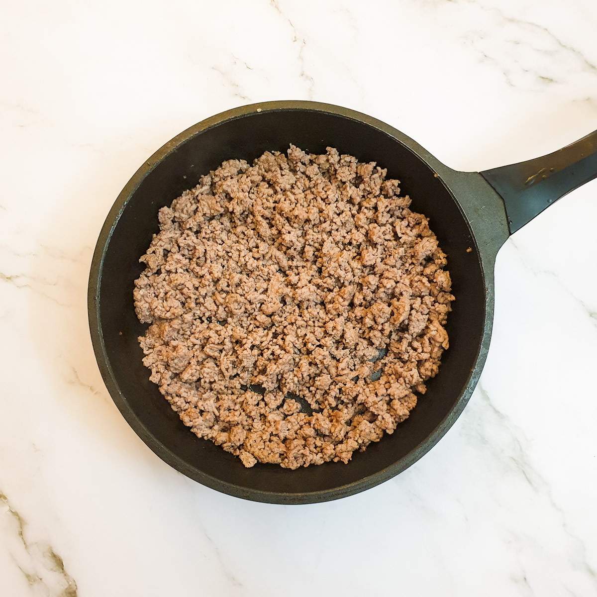 Mince being browned in a frying pan.