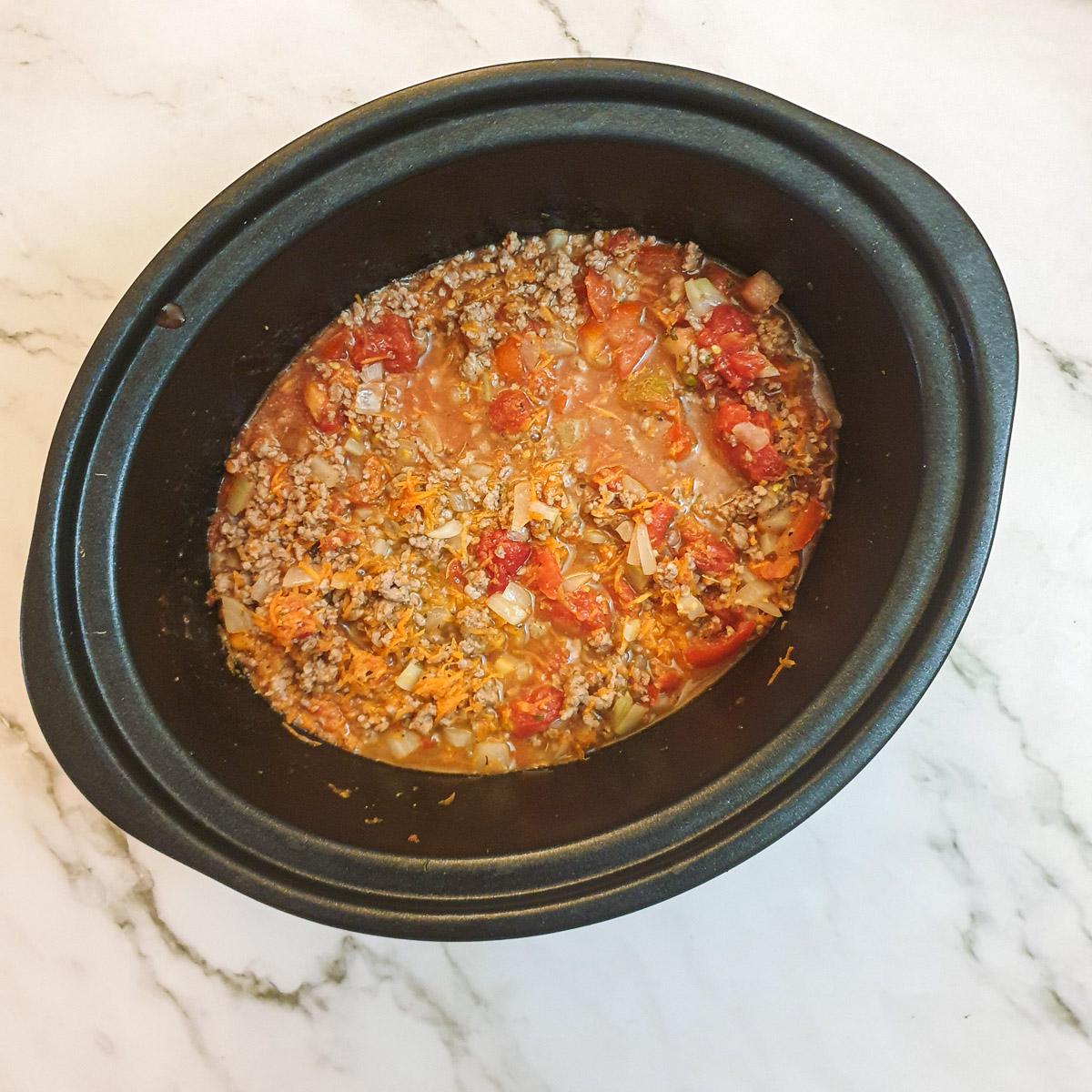 Bolognese sauce in a slow-cooker ready to be cooked.