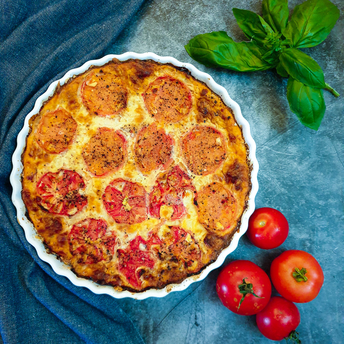 Overhead shot of a crustless tomato and onion quiche.