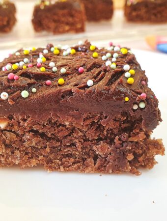 Close up of chocolate weetbix crumble cake with more slices out of focus in the background.