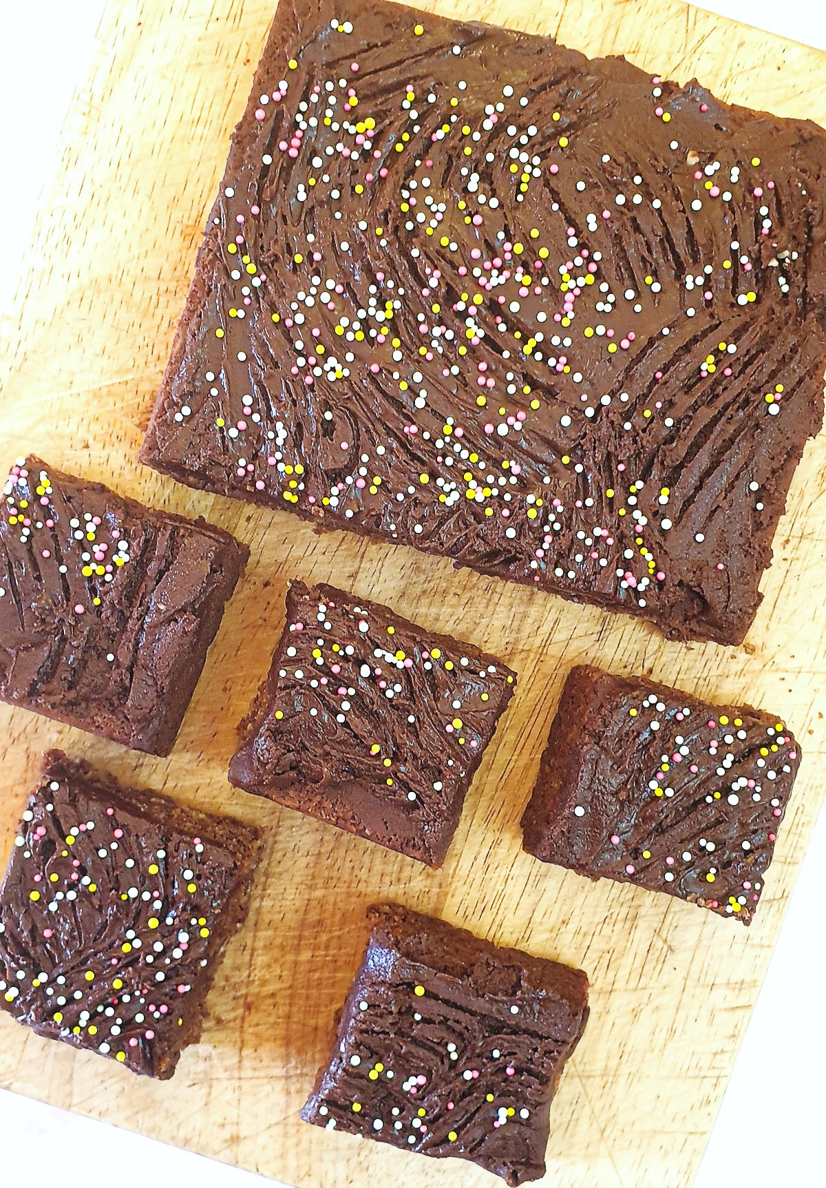 Overhead shot of squares of chocolate weetabix slice on a wooden board.