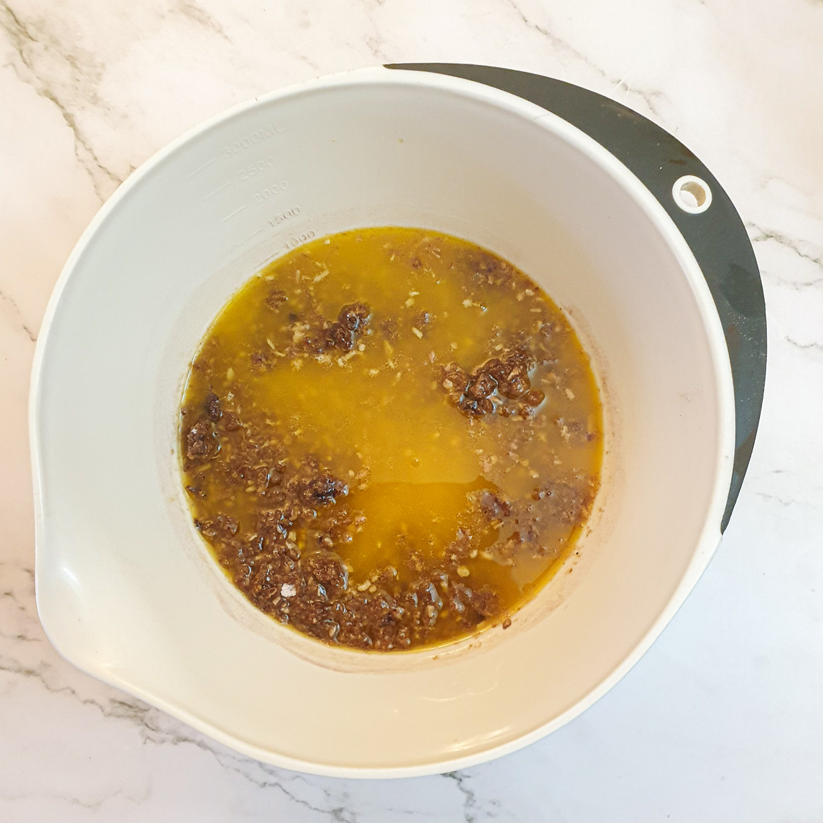 Melted butter added to dry ingredients in a mixing bowl.