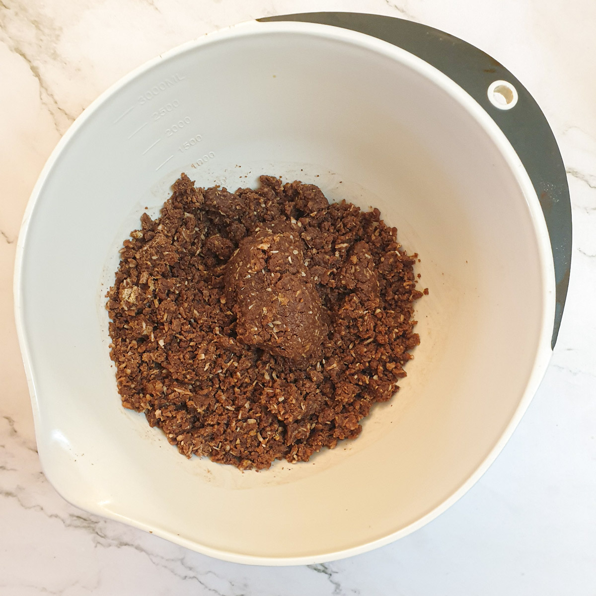 Weetbix cake batter in a mixing bowl, showing texture of batter.