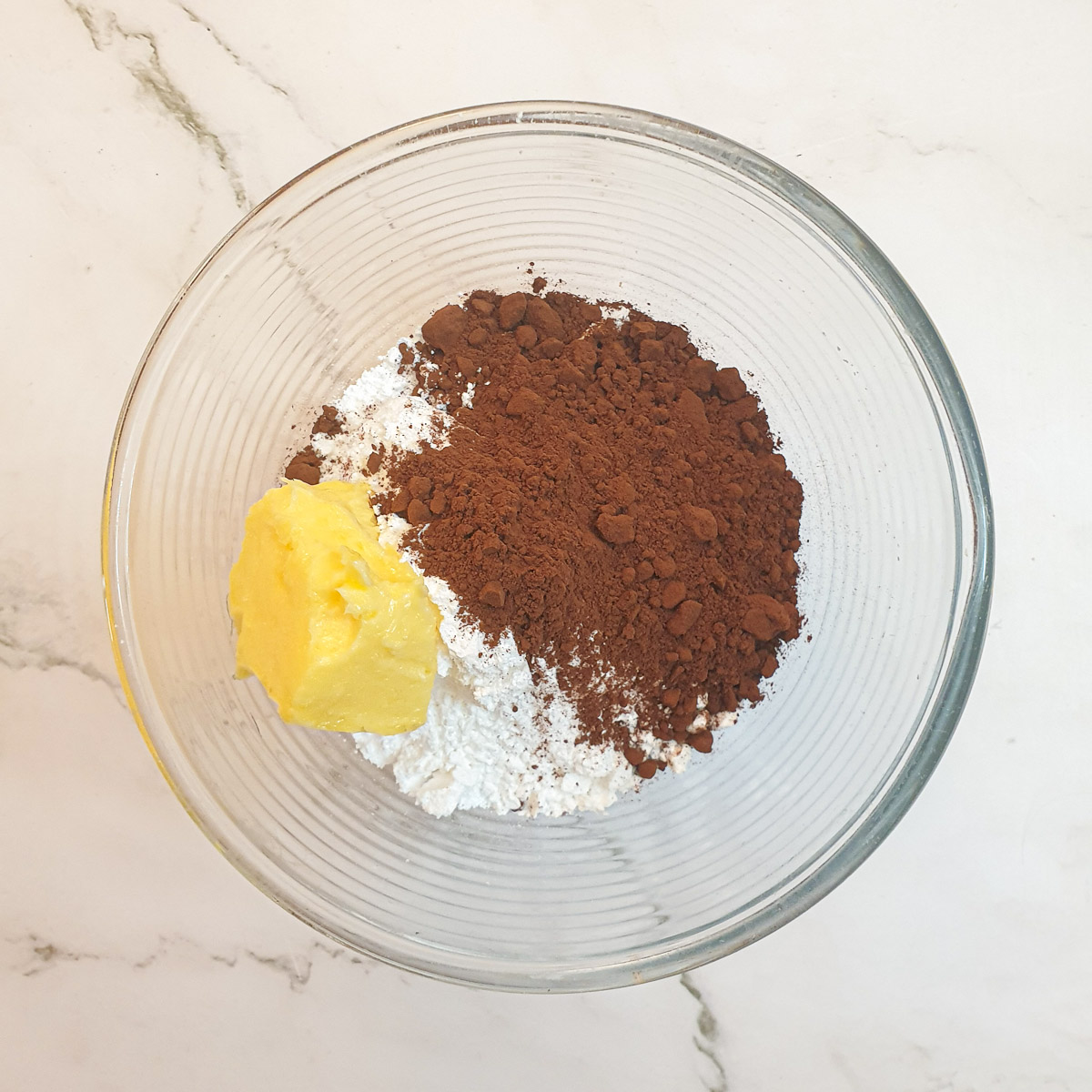 Ingredients for chocolate icing in  mixing bowl.