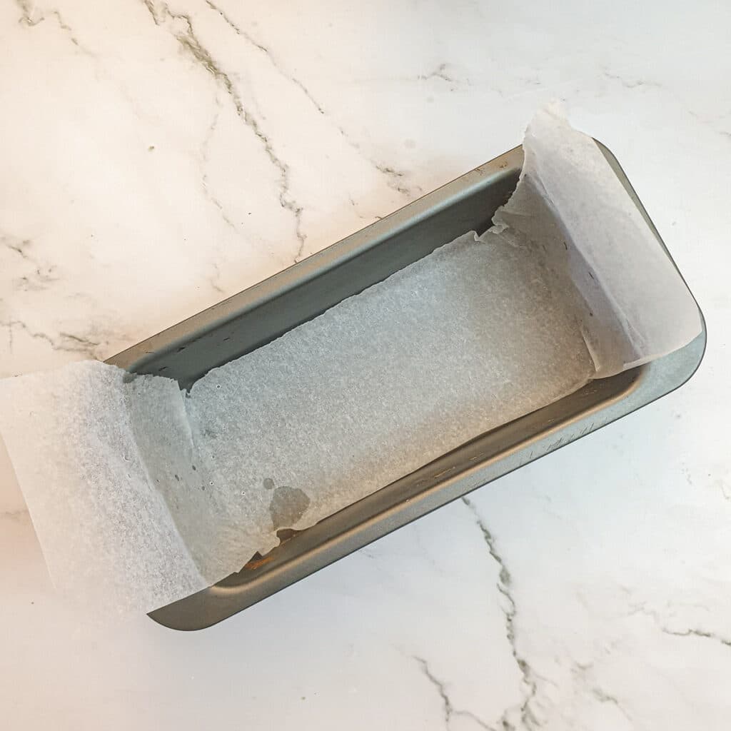 A loaf tin lined with baking parchment.